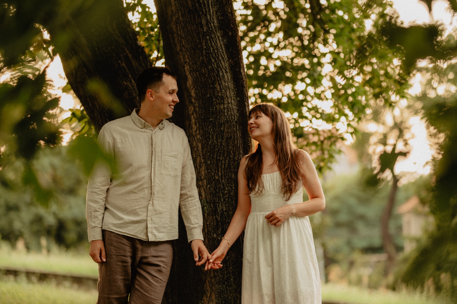 Aleksandra i Filip trzymają się za ręce pod drzewem